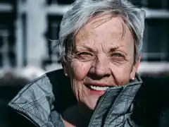 strahlende Seniorin mit direktem Blickkontakt